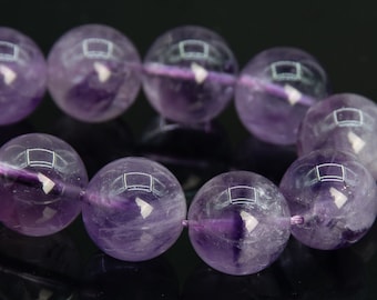 May include: A strand of purple amethyst beads, each bead is round and smooth with a slight shimmer.