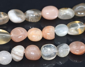 May include: A strand of smooth, oval-shaped sunstone beads in shades of white, peach, and light brown. The beads have a subtle shimmer and are strung on a clear thread.
