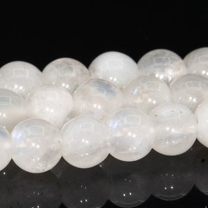 May include: A strand of white moonstone beads. The beads are round and smooth, with a slight iridescent sheen.
