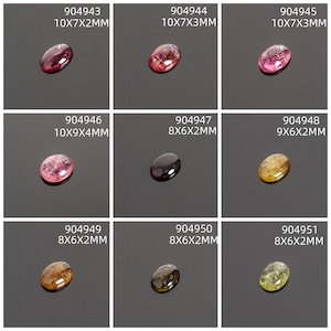 May include: Nine oval gemstones in various colors, including pink, black, and yellow. Each stone is labeled with a unique number and dimensions in millimeters. The gemstones are displayed on a dark surface.