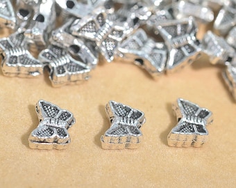 May include: Silver butterfly charms with a detailed design. The charms are small and have a delicate look.