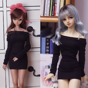 May include: Two dolls wearing black off-the-shoulder dresses with long sleeves. The doll on the left has brown hair and a pink headband. The doll on the right has silver hair.