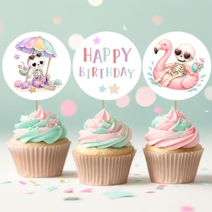 May include: Three cupcakes with pastel pink and mint green frosting, each topped with a circular card. The left card shows a skeleton under a rainbow umbrella, the center says HAPPY BIRTHDAY in pastel letters, and the right shows a skeleton on a flamingo float.