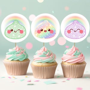 May include: Three cupcakes with pastel pink and mint green frosting, each topped with a circular paper topper featuring a smiling, glittery character under a rainbow. The characters are light green, iridescent, and light purple, respectively.