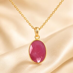 Peut inclure: Un collier en or avec un pendentif en pierre précieuse rose foncé de forme ovale et à facettes. Le pendentif est serti dans une monture en or lisse avec une bélière simple, suspendu à une fine chaîne en or aux maillons circulaires.