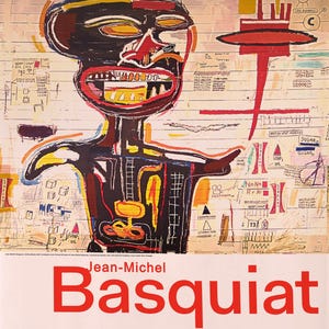 May include: Poster for the Jean-Michel Basquiat exhibition at the Fondation Louis Vuitton. The artwork features a black figure with red, yellow, and white accents. The poster includes the artist's name and exhibition dates.