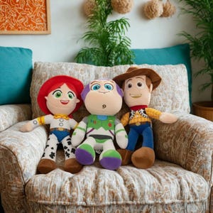 May include: Three plush character dolls from the Toy Story movie franchise. Jessie, Buzz Lightyear, and Woody are seated on a patterned armchair. Jessie has red hair and a cow-print outfit. Buzz is in a green and purple space suit. Woody wears a cowboy hat and vest.