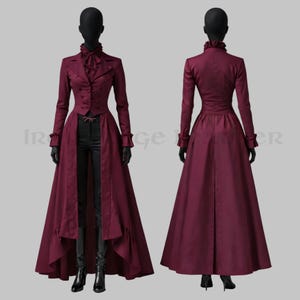 Könnte beinhalten: Ein burgunderfarbener langer Mantel mit hohem Kragen, gerüschten Manschetten und Knopfleiste. Der Mantel hat einen langen, fließenden Rock und wird auf einer Schaufensterpuppe präsentiert. Der Mantel wird mit einer schwarzen Hose und Stiefeln kombiniert. Der Stil erinnert an die viktorianische Mode.
