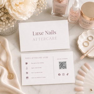 Pode incluir: Uma composição plana com produtos para unhas e dois cartões brancos. Os cartões dizem "Luxe Nails AFTERCARE" e "NAILS AFTERCARE GUIDE". O guia inclui dicas e um código QR. Frascos de verniz, um pincel e um prato com anéis também são visíveis.