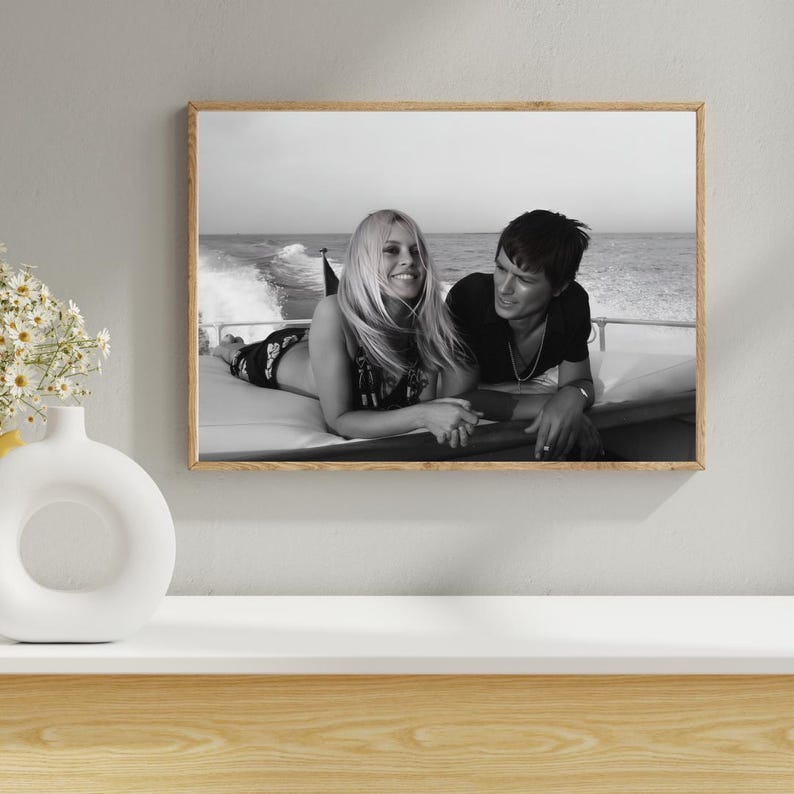 May include: A white ceramic mug with a black handle and the text "But First, Coffee" in a black, bold font. The mug is sitting on a wooden surface. The mug is approximately 4 inches tall.