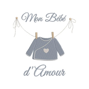 Puede incluir: Un body azul de bebé colgado de una cuerda para tender la ropa con el texto "Mon Bébé d'Amour" en letra cursiva.
