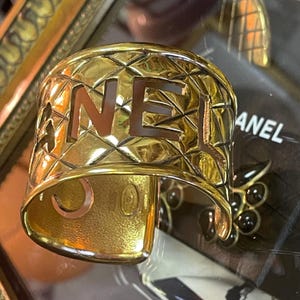 Sublime et iconique manchette Chanel en métal doré
