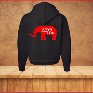Puede incluir: Sudadera con capucha negra con una silueta de elefante roja y el texto "&Delta;&Sigma;&Theta; 1913" en la espalda.