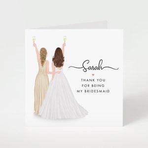 May include: A white greeting card with an illustration of two women in formal dresses, toasting with champagne flutes. The card reads "Sarah, Thank you for being my bridesmaid."