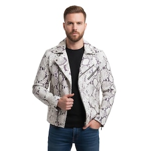 May include: A white and gray snakeskin-patterned leather jacket with a black zipper closure. The jacket has a classic biker style with a notched collar and asymmetrical zipper. The person in the image is wearing a black t-shirt and blue jeans.