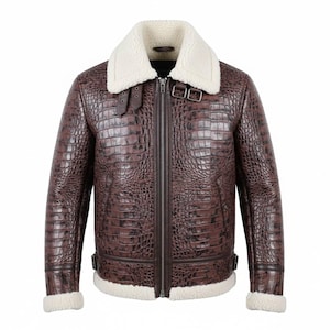 Może przedstawiać: Brązowa skórzana kurtka o fakturze skóry krokodyla. Kurtka posiada biały kołnierz i podszewkę z owczej wełny, zamek błyskawiczny z przodu i detale z klamrami. Klasyczny styl lotniczy.