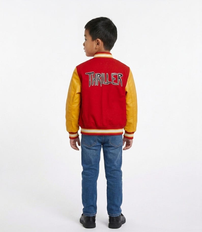 May include: A red and yellow varsity jacket featuring the word THRILLER embroidered on the back in a stylised font. The jacket has long yellow sleeves, a red body, and striped ribbed trim at the collar, cuffs, and hem, paired with blue denim jeans.
