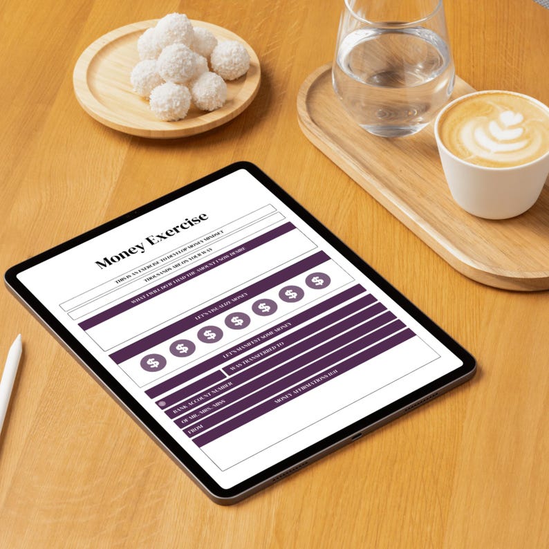 Op de afbeelding: Een digitale tablet met een "Money Exercise" werkblad, met secties voor budget, doelen en details van geldoverdrachten. De afbeelding bevat een kopje koffie, een glas water en een bord met kokossnoepjes op een houten oppervlak.