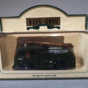 以下が含まれることがあります： Days Goneのダイキャスト製消防車のモデル。オリジナルのパッケージに入っています。濃い緑色のトラックには黒い車輪と茶色の梯子が付いています。「CIVIL DEFENCE CORPS」の文字が側面に印刷されています。パッケージには「DAYS GONE」と「MADE IN ENGLAND」と書かれています。