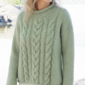 以下が含まれることがあります： ハイネックのライトグリーンのケーブルニットセーター。セーターは中央にケーブルのデザインがあり、柔らかく質感のある糸で作られています。長袖とゆったりとしたフィット感は、快適なスタイルを提供します。