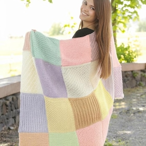 May include: A rectangular knit blanket featuring a patchwork design of large squares in pastel colors including mint green, soft pink, cream, pale yellow, and lavender. The blanket displays a variety of textures with alternating ribbed and seed stitch patterns.
