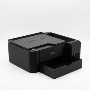 May include: A black Epson printer with a pull-out tray. The printer has the Epson logo on the top and front. The printer is on a white background.