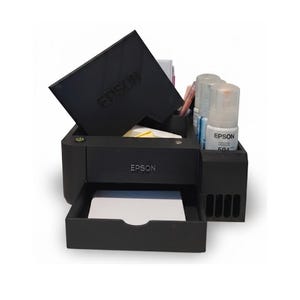 May include: Black Epson printer with a tray, ink bottles, and a top cover. The Epson logo is visible on the printer and cover. The printer is on a white background.