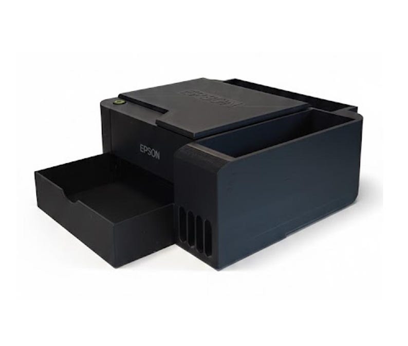 May include: A black Epson printer with a pull-out tray and a large ink reservoir. The printer has a flat top and the Epson logo is visible on the side. The design is modern and compact.