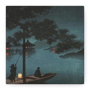 May include: A serene, dark blue and black Japanese-style print depicts a nighttime lake scene. Silhouetted figures are in a boat with a lantern, and another figure is fishing. Buildings with red lights are on the shore, and a large tree frames the scene.