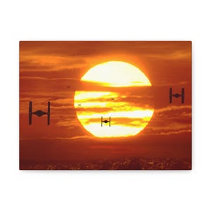 May include: Canvas art print depicting a sunset with a large, bright sun and dark clouds. Several black TIE fighter spacecraft silhouettes are visible, evoking a science fiction theme. The color palette is dominated by warm oranges and reds.