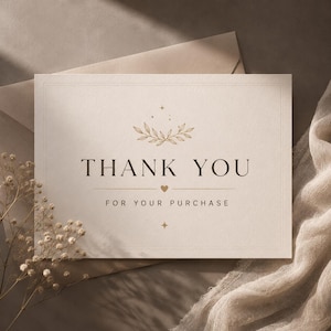 Op de afbeelding: Een rechthoekige gebroken witte bedankkaart met de tekst THANK YOU FOR YOUR PURCHASE in een donker schreeflettertype. Het ontwerp bevat een goudkleurige illustratie van een botanische tak, een klein hartje en steraccenten in het midden.