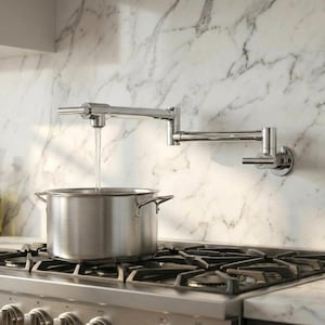 Puede incluir: Una olla de acero inoxidable se encuentra sobre una estufa de gas, debajo de un grifo cromado para llenar ollas. El agua fluye del grifo a la olla. El grifo está montado en un salpicadero de mármol. La estufa tiene rejillas negras.