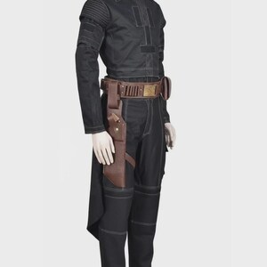 Pode incluir: Um conjunto de camisa de manga comprida e cal&ccedil;as pretas com costuras brancas, detalhes canelados nos ombros e um cinto utilit&aacute;rio de couro castanho com coldre e fivela met&aacute;lica, exibido num manequim sobre um fundo neutro.