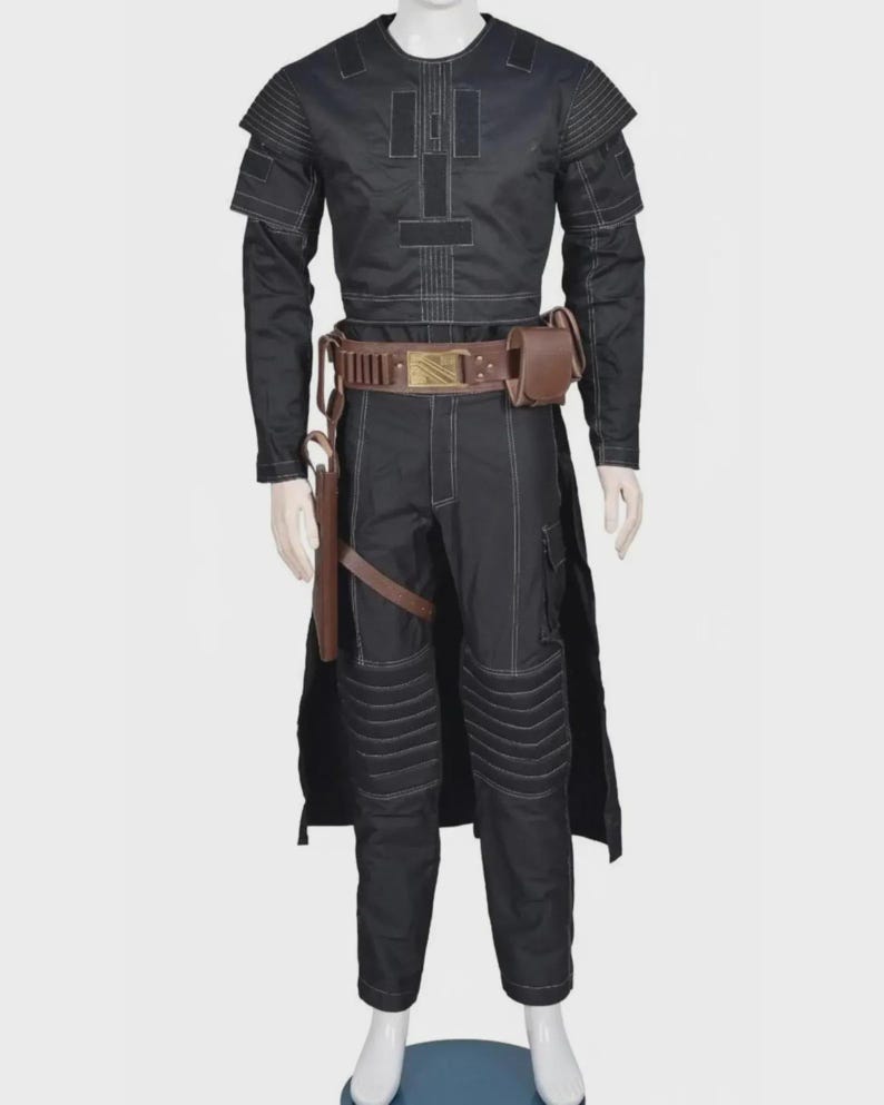 Pode incluir: Um conjunto preto de camisa de manga comprida e cal&ccedil;as com costuras brancas em contraste, pain&eacute;is canelados nos ombros e joelhos, e um cinto utilit&aacute;rio castanho com coldre e bolsa, exibido num manequim branco.