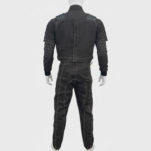 May include: A black two-piece outfit consisting of a jacket and trousers. The jacket features shoulder padding, a central vertical seam, and white contrast stitching. The sleeves have a geometric triangular pattern and ribbed cuffs. The pants feature white vertical seams.