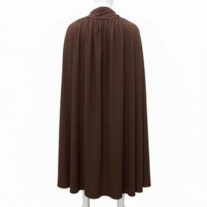 May include: A floor-length brown cape featuring a gathered neckline with a draped collar. The garment is constructed from a solid-coloured fabric that hangs in vertical folds, extending from the shoulders down to the hemline in a full silhouette.