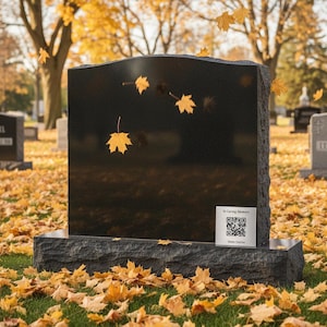 May include: A black granite headstone with a rectangular shape and a slightly curved top. The headstone is set on a dark grey base, with a small plaque that reads "In Loving Memory" and a QR code. Yellow leaves fall around the headstone.