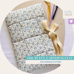 Può includere: Una custodia per laptop trapuntata con un motivo floreale blu e crema. La custodia è rettangolare con un design imbottito. L'immagine mostra anche forbici, matite e un nastro color crema. Il testo sull'immagine recita "THE PUFFY LAPTOP SLEEVE" e "PDF SEWING PATTERN."