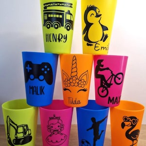 Könnte beinhalten: Eine Ansammlung von neun bunten Kunststoffbechern, die in einer Pyramide angeordnet sind. Jeder Becher zeigt ein einzigartiges schwarzes Grafikdesign und einen personalisierten Namen wie Henry, Emil, Malik, Tilda, Max, Lena, Holly, Leo und Tilda.