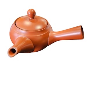 May include: A reddish-brown ceramic teapot with a side handle and a spout. The teapot has a rounded body, a lid with a small knob, and a long, angled handle. The spout is positioned on the opposite side of the handle.