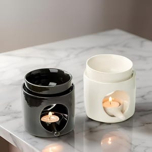 Peut inclure: Deux diffuseurs d'huiles essentielles en céramique, un noir et un blanc. Chacun a un bol amovible et une cavité pour une bougie chauffe-plat allumée. Le diffuseur noir a une finition brillante. Le diffuseur blanc a une finition mate.