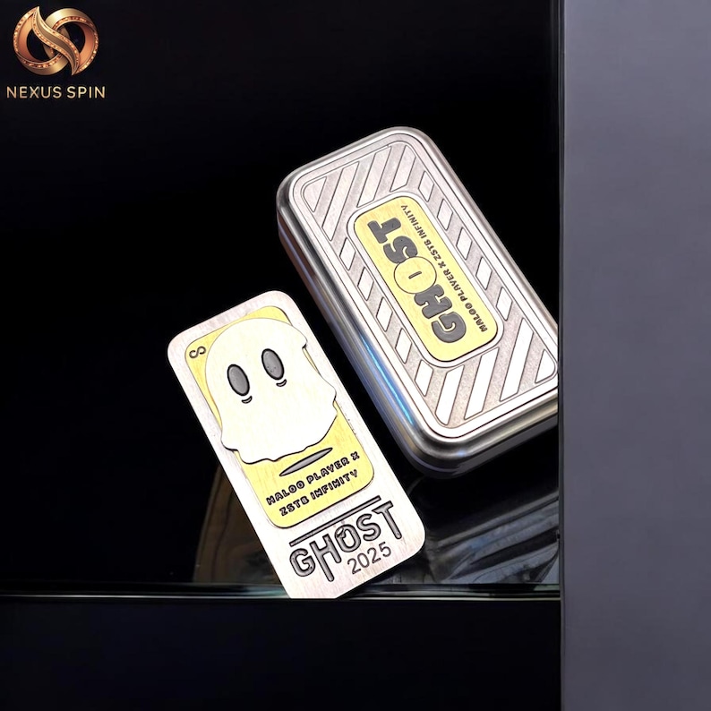 May include: A silver rectangular box and a matching card with a ghost design. The box and card have the word "GHOST" in yellow and black. The card also has the text "NALOO PLAYER X 2STD INFINITY" and "2025".
