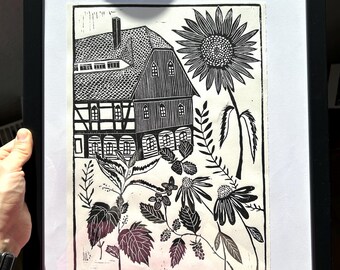 Grabado en linóleo "Jardín de verano de Alta Lusacia": casa con entramado de madera, flores, plantas del jardín.