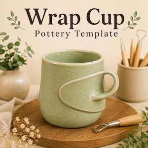 May include: A sage green ceramic mug with a speckled finish and a unique wrap-around handle design. The text "Wrap Cup Pottery Template" is displayed above the mug. The mug sits on a round wooden board alongside pottery tools and greenery.