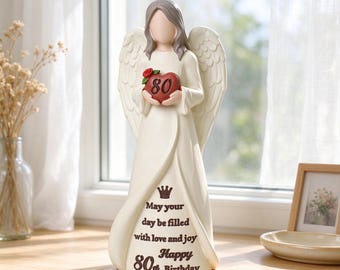 May include: A cream-colored angel figurine with gray hair and large wings, holding a red heart marked with the number 80. The gown features a crown icon and the text: May your day be filled with love and joy Happy 80th Birthday.