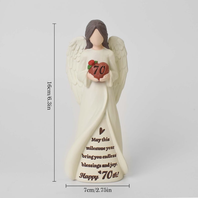 May include: A cream-colored angel figurine with brown hair, holding a red heart with the number 70 and a small green leaf. The base features the text: May this milestone year bring you endless blessings and joy. Happy 70th! Height is 6.3 inches.