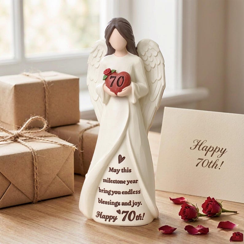 May include: A cream-colored angel figurine with brown hair and feathered wings, holding a red heart marked with the number 70 and a small red rose. The gown features the text: May this milestone year bring you endless blessings and joy. Happy 70th!