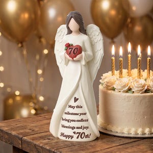 May include: A cream-colored angel figurine with brown hair and large wings, holding a red heart with the number 70 and a small rose. The dress features the text: May this milestone year bring you endless blessings and joy. Happy 70th!