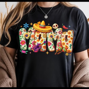 May include: Black t-shirt with the word "MAMA" in a floral design. The letters are decorated with flowers, a sombrero, a guitar, a skull, and chili peppers. The shirt has a crew neck and short sleeves.