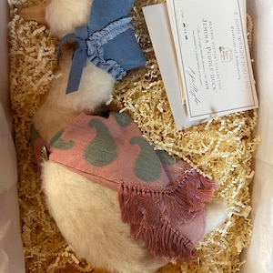 May include: A Jemima Puddle-Duck plush doll from the Beatrix Potter Collection, nestled in a box with straw-like packing material. The duck is cream-colored with a blue bonnet and a pink shawl with green pear shapes. A certificate of authenticity is included.